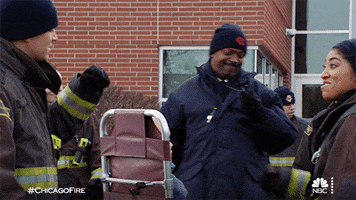 TV gif. Two firefighters on Chicago Fire come together for a fist bump, then turn and walk away. 