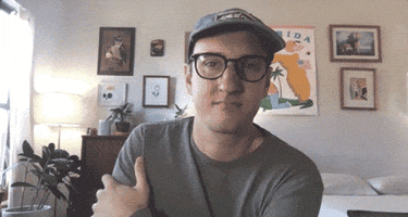Celebrity gif. Tyler Menzel, in a home environment, appears to be listening, nodding slightly and then saying "awesome," which appears as text.