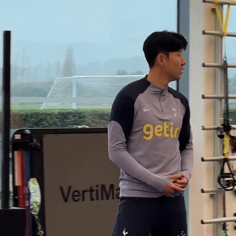 Sports gif. Heung-Min Son and Pape Matar Sarr from Tottenham Hotspur hug each other in the gym.