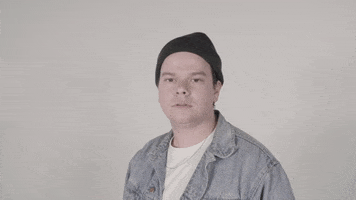 Video gif. We zoom in toward a young man wearing a beanie as he nods his head in agreement.
