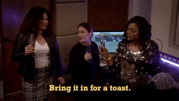 TV gif. Two women follow the lead of Taraji P. Henson as Cookie on Empire who puts her glass out in the center and says "Bring it in for a toast," which appears as text.