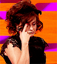 Celebrity gif. Helena Bonham Carter twirls a finger by her temple then flicks out her hand as her eyes go wide and her face looks skeptical.