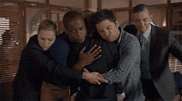 TV gif. From Psych, Maggie Lawson as Juliet, Dule Hill as Gus, James Roday as Shawn, and Timothy Omundson as Carlton, crowd in pairs around Kirsten Nelson as Karen, hugging her.