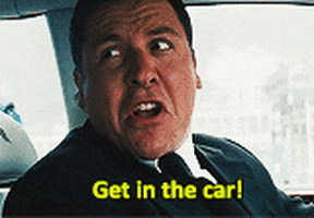Movie gif. Jon Favreau as Happy Hogan in Iron Man 2 shouts at us from the driver's seat. Text, "Get in the car!"