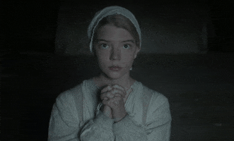 Movie gif. Anya Taylor-Joy as Thomasin in "The Witch," wearing colonial-era clothes, clasps her hands in prayer and looks just above us up into the heavens, moving her lips ever so slightly as she prays.