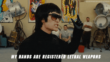 Movie gif. Mike Moh as Bruce Lee in Once Upon A Time In Hollywood. He rolls his fingers up into a fist menacingly and says, "My hands are registered lethal weapons."