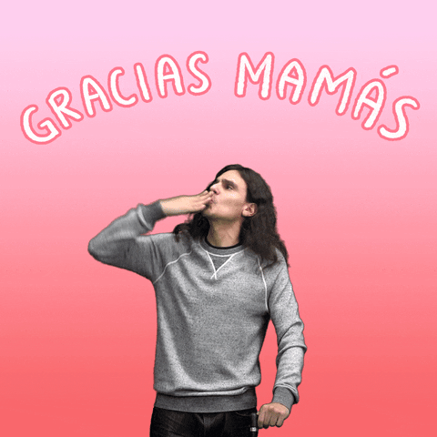 Digital art gif. Man seen from the waist up blows kisses into the air around him with vigor. Little red cartoon hearts appear around his outstretched hand. Above his head in pink letters, text reads, "Gracias Mamas," everything against an ombre pink and white background.