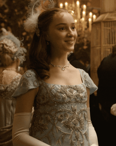 TV gif. Phoebe Dynevor as Daphne in Bridgerton at a ball laughs or giggles suddenly and covers her mouth with her gloved hand, looking back up a little self-consciously. 