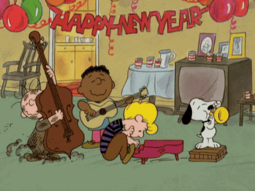 TV gif. Snoopy, Franklin, Schroeder and Pig-Pen from Charlie Brown all play their instruments in celebration while a red banner hangs between balloons. The banner reads, "Happy New Year."
