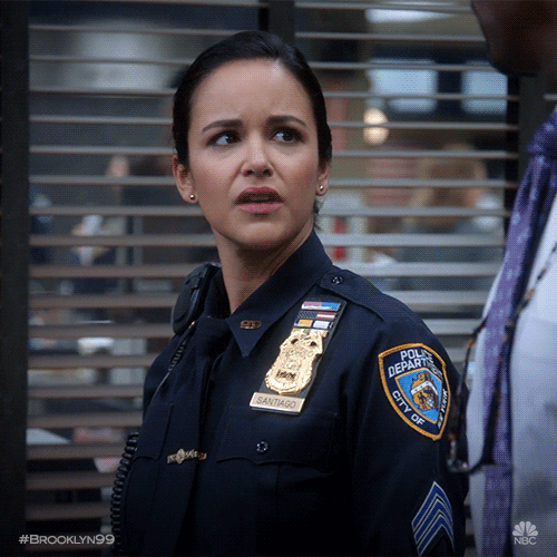 TV gif. Melissa Furmero as Amy Santiago on Brooklyn Nine-Nine wears a police uniform and looks up at a man next to her with disgust, frowning and furrowing her eyebrows.