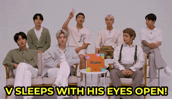 Tonight Show gif. BTS is being interviewed and RM says, "V sleeps with his eyes open!" The camera pans to V and he smiles and says, "Yeah."