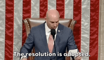 Video gif. Man wearing a blue suit in front of the house speaker's chair and an American flag filling the background. He looks down at a piece of paper in his hand, then bangs a gavel and says, "The resolution is adopted."