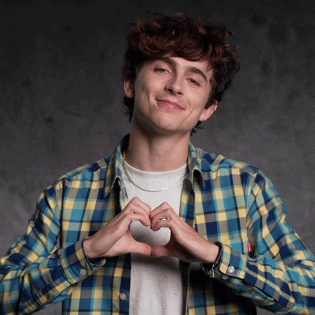 Celebrity gif. Timothee Chalamet presses his hands together, forming the shape of a heart, in front of his chest, smiling at us and laughing a little.