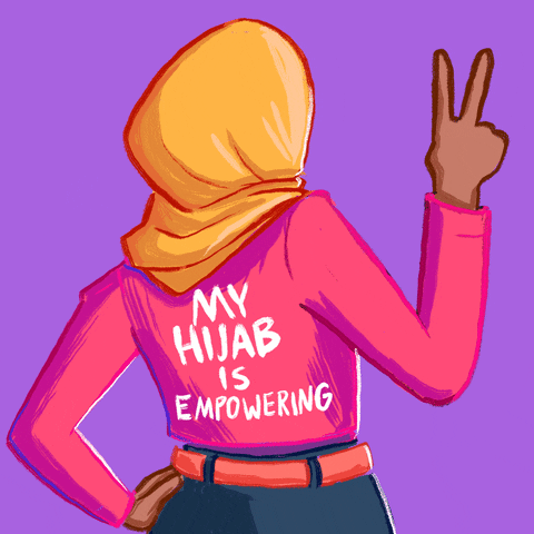 Illustrated gif. Woman wearing a hijab faces away from us and waves a peace sign with her fingers held up against a lilac background. Text on the back of her shirt reads, "My hijab is empowering."