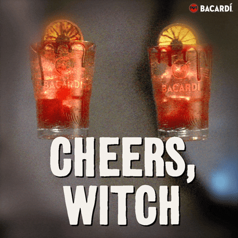 Sponsored gif. Two orange cocktails in glasses bearing the Bacardi logo toast midscreen. The glasses are rimmed in a substance that resembles blood. Text reads "CHEERS, WITCH."