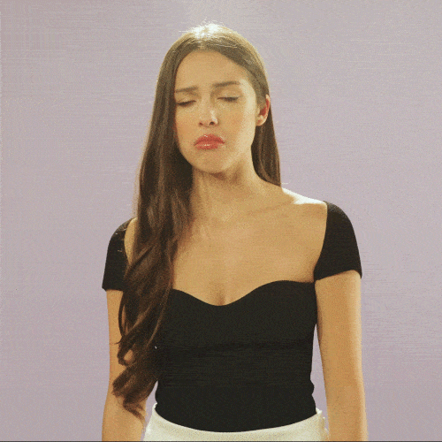 Video gif. Olivia Rodrigo stares at us with a bored expression on her face, making a long exaggerated puking face, flashing her eyes like she can't believe you. 
