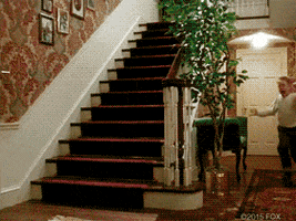 Movie gif. Macaulay Culkin as Kevin McCallister running wildly through the house and waving his arms.