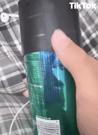 Video gif. A hand holding a Sprite pops a black lid off the top of the can. The camera looks inside the darkness of the open can top where a creepy smiling face emerges inside.