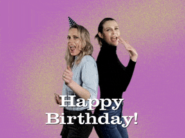 Video gif. Two women wearing jeans, one in a birthday hat, as they stand back to back and do a cute, sassy coordinated dance, looking at us with wide-mouthed happy expressions against a purple and gold background. Text, "Happy birthday!'