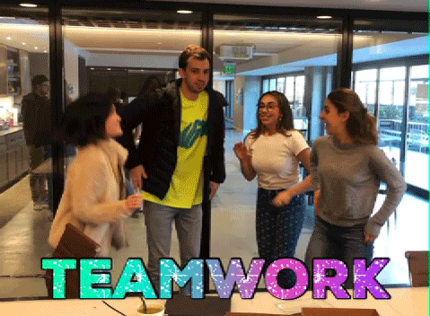 TV gif. Four casually dressed coworkers jump in the air and high-five each other as a group, clearly elated about a success. Rainbow colored sparkling text reads "Teamwork."