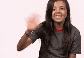 Video gif. Young brown-haired girl smiles and waves hello.