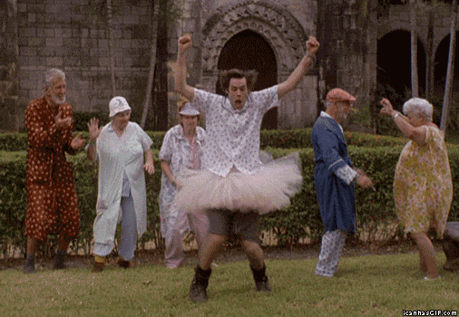 Gif s tancujícím Jimem Carreym v sukni se starými lidmi obléknutými v županech a pyžamech.