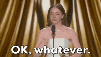Oscars 2024 GIF. Emma Stone frantically waves her hand to brush a thought aside and shakes her head while she says, "Ok, whatever."