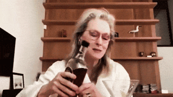 Celebrity gif. Meryl Streep is about to pour scotch into her cup but she stops and looks at the bottle, considering. She raises both eyebrows and looks at us as she makes a decision, and swigs directly from the bottle.