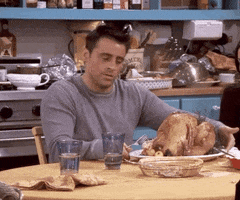 Friends gif. Looking determined, Matt LeBlanc as Joey turns an entire roasted turkey on a plate that sits in front of him and holds up a fork. He says, “You are my Everest.”