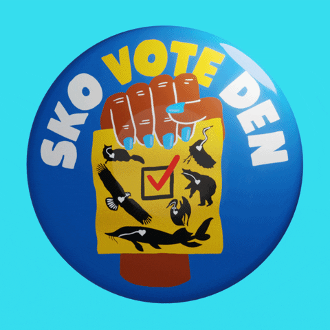 Digital art gif. Azure blue button pin with a fist holding a ballot with animals native to North America on it, spins on its access on a cyan background. Text, "Sko-vote-den."