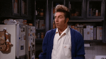 Seinfeld gif. Looking shocked, Michael Richards as Kramer holds up a hand as he backs up and yells, “Sorry!”