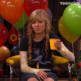 TV gif. Jennette McCurdy as Sam Puckett from iCarly sits among party balloons, giving a bored, uninterested toast with a plastic cup.