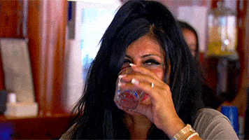 Reality TV gif. Big Ang on Mob Wives sips from a glass and she purses her big red lips in disgust. She gags a little.