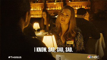 TV gif. Mandy Moore as Rebecca in This Is Us sitting at a table with someone, frowning facetiously and saying, "I know. Sad, sad, sad."
