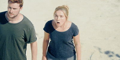 Movie gif. Florence Pugh as Dani and Jack Reynor as Christian in Midsommar. She sees something incredibly traumatizing and her jaw drops in total shock as her hand clamps onto Christian's arm. She covers her mouth with her hand as she staggers back in fear.