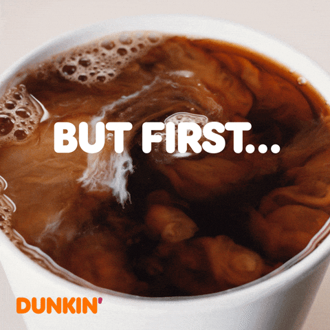 Sponsored gif. Cream swirls at the top of a mug of Dunkin’ Donuts coffee. Text reads, “But first, coffee.”