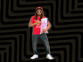 Celebrity gif. Lil John holds a bag of Boom Chicka Pop popcorn and pops pieces into his mouth, looking interested in something.