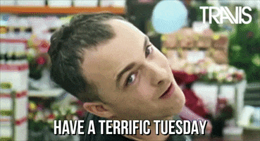 Celebrity gif. Fran Healy of Travis stands in a grocery store looking forward with a tilted head and slight smile as the camera zooms away from his face on loop. Text, "Have a terrific Tuesday".