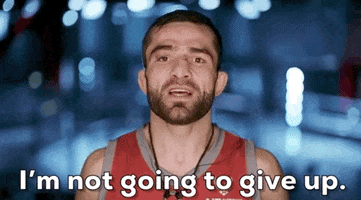 Video gif. Timur Valiev on "The Ultimate Fighter" has cuts on his face as he shakes his head and says, "I'm not going to give up."