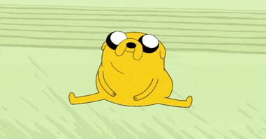 Cartoon gif. Jake the Dog from Adventure Time sits in a split on the floor and blows a kiss.