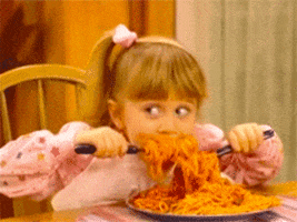 TV gif. Mary Kate or Ashley Olsen as Michelle Tanner from Full House, devours a huge plate of spaghetti using two utensils.