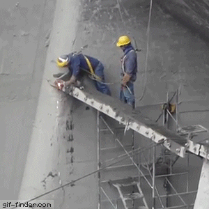 Video gif. Two construction workers weld a beam that swings loose, knocking them over and leaving them dangling from their harnesses.
