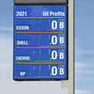 Gas price board showing the 2021 oil profits of Exxon, Shell, Chevron, and BP.