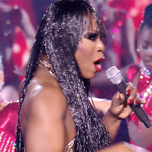 Reality TV gif. Aria B Cassadine points at us as she sings, performing on Queen of the Universe with back-up dancers. Text, "you."