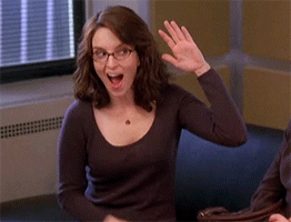 TV gif. Tina Fey as Liz from 30 Rock. She looks incredibly pleased and puts her hand up for a high five which she slaps herself. She rounds off this interaction by pointing a finger gun at the person she's speaking with. 