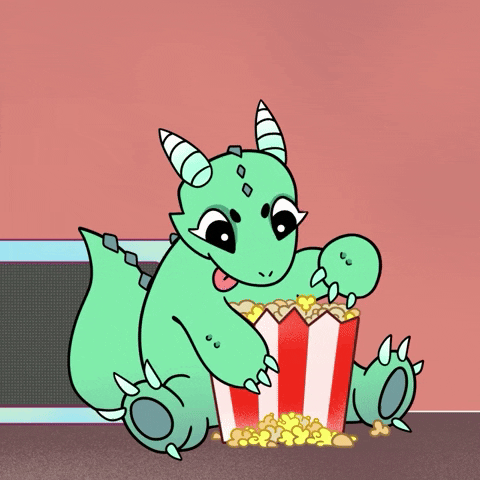 Cartoon gif. A green dragon sits on the floor with a bucket of popcorn between its legs and happily shovels handfuls of popcorn into its mouth.