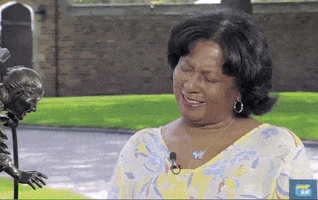 Reality TV gif. A woman on Antique Roadshow chuckles and then looks up as if flattered. Text, "Oh, my gosh."