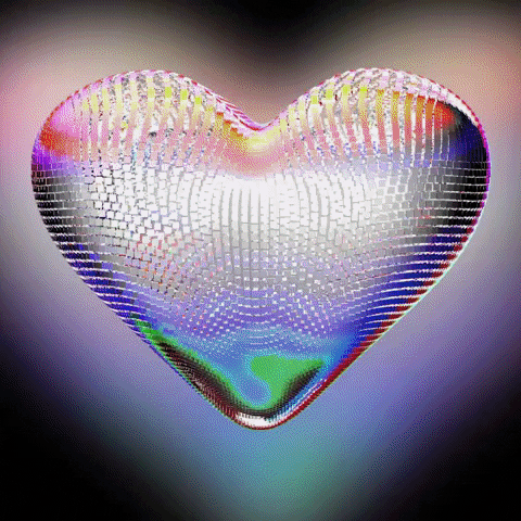 Digital art gif. A heart-shaped disco ball rotates in a circle, reflecting a rainbow of colors.