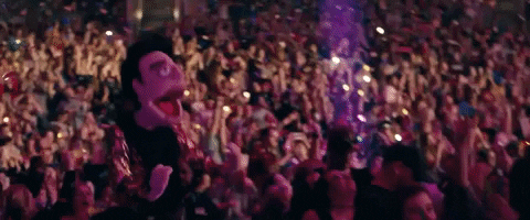 Music video gif. In the Panic! At The Disco video for Hey Look Ma, I Made It, a muppet of Brendon Urie dances with his mouth gaping open in front of a crowd showered with confetti. Integrating live art performances into your event: Adding a unique and creative touch.