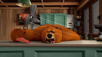 Cartoon gif. Brown bear lies on a kitchen counter with its tongue hanging out, holding a fan that blows directly on him, looking miserably hot. 
